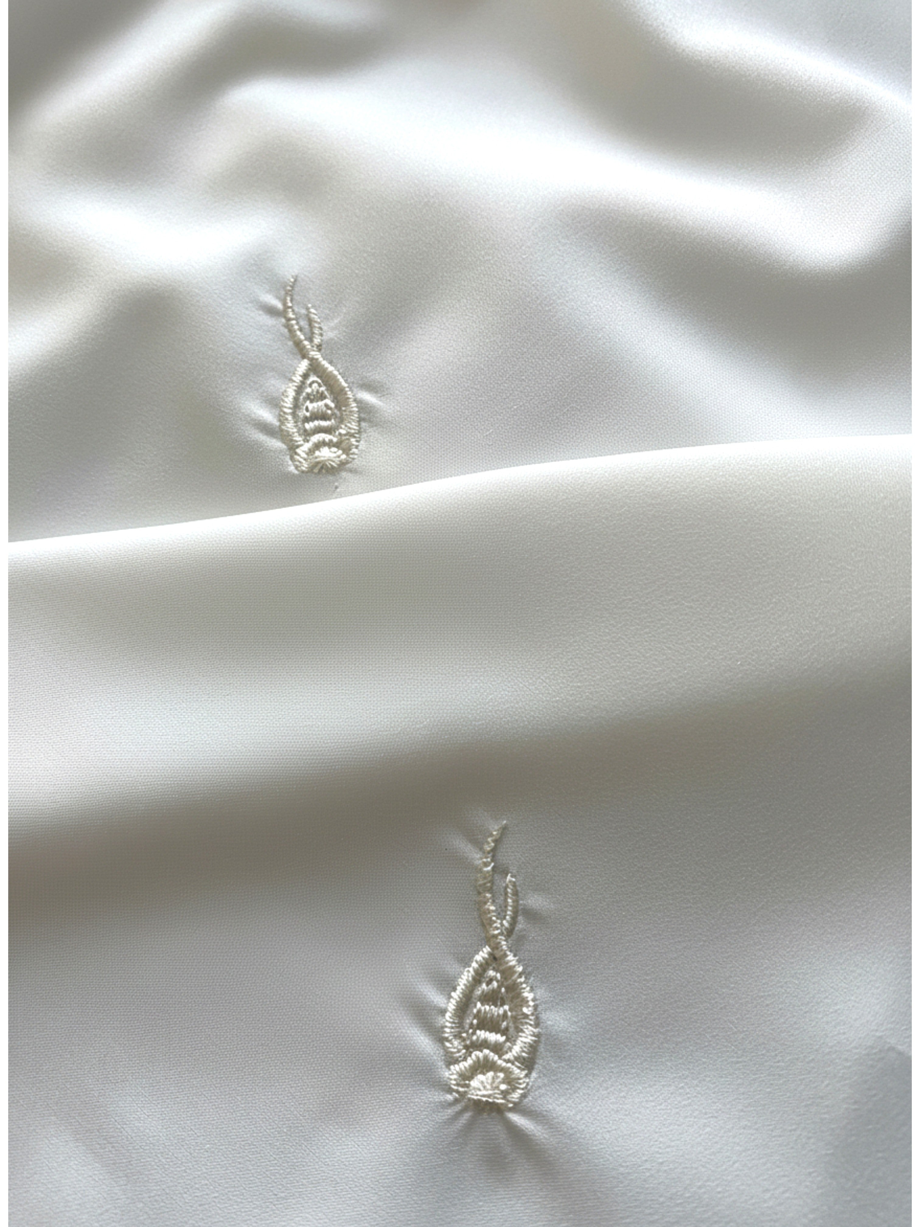 White hijab with repeated tulip embroidery in lightweight polyester fabric